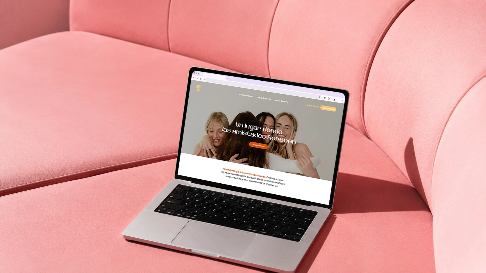 Hay un ordenador portátil sobre un sofá rosa, en cuya pantalla se ve una página web con una imagen de cabecera en la que aparecen tres personas sonrientes y un texto en sueco.